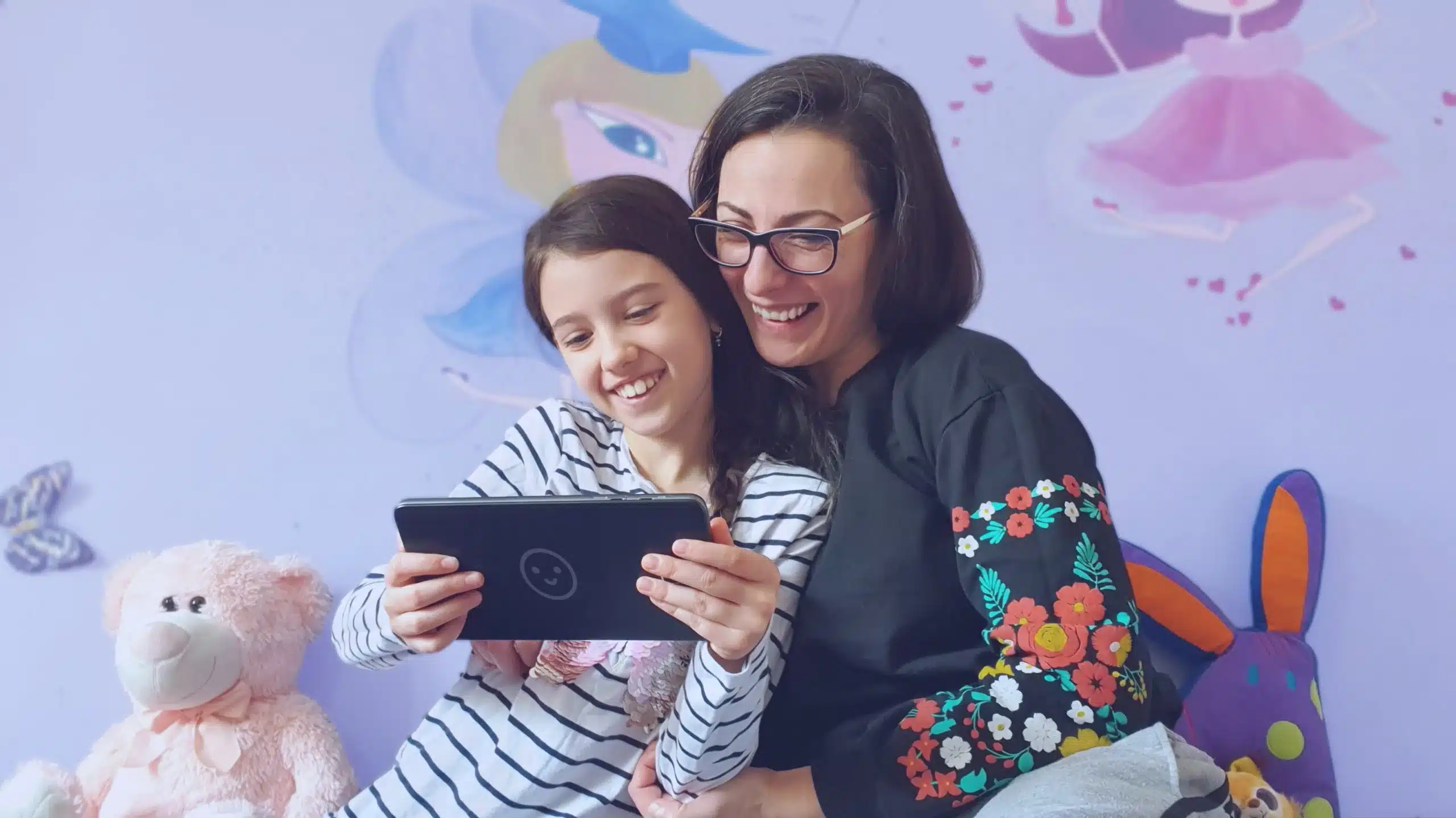 une mère et sa fille qui regardent ensemble une tablette