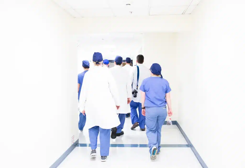 photo d’un groupe de medecins marchant de dos dans un hopital