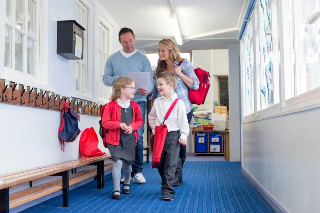 photo d’une famille avec 2 enfants dans un couloir d’une école